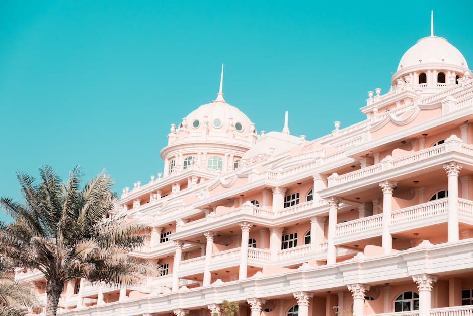Elegant hotel facade with palm trees under a blue sky